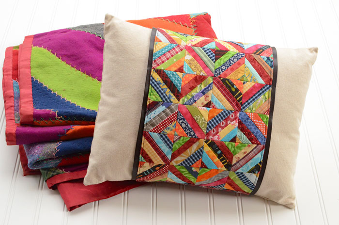 Pillow with Patchwork Pillow Wrap sitting next to a folded crazy quilt