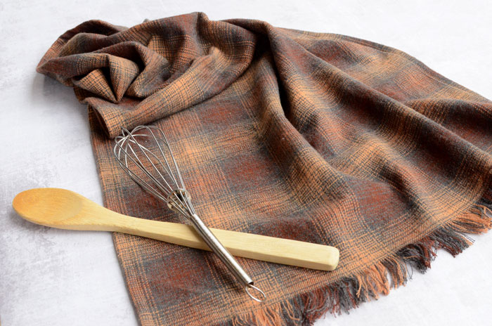 Flannel Tea Towel with Fringe, shown with spoon and whisk